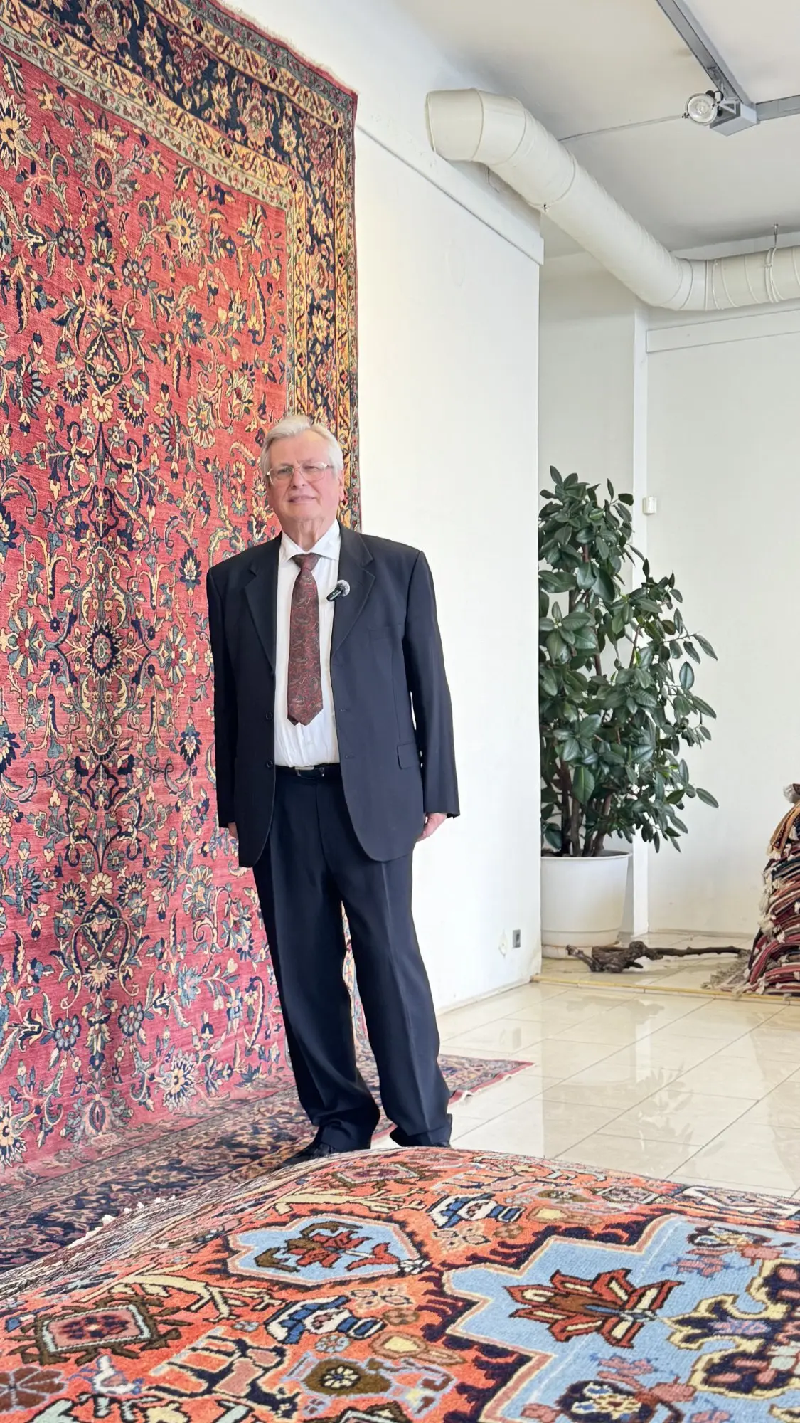 Rudolf Koppensteiner mit persischem Teppich im Showroom